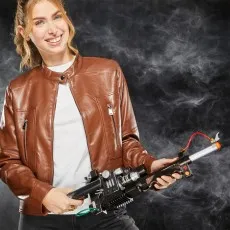 A happy young woman in a brown leather jacket holds a Ghostbusters Proton Pack wand