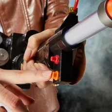 A person in a brown leather jacket holds a Ghostbusters Proton Pack wand