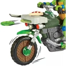 A close-up of a Leonardo action figure on his motorcycle, launching a green throwing star from the front.