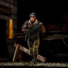 Action figure of a man in a brown jacket and combat gear walking in a detailed diorama.