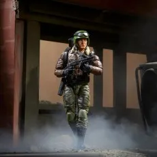 G.I. Joe toy of Hawk in a brown flight jacket, holding a gun, in a dusty setting.