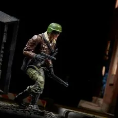 The G.I. Joe toy of Hawk in a brown bomber jacket, crouching and holding a weapon.