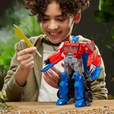 A child poses the Optimus Prime figure while holding its golden sword accessory