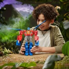 A smiling child holds the Optimus Prime figure in its Beast-Mode with a lion head on its chest and blue rotor blades extended from its back