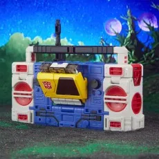 A detailed view of the Transformers Twin-Cast figure in its boombox mode against a blurred, otherworldly background