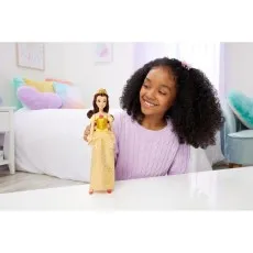 A child holds a Belle fashion doll in a yellow dress, looking at it with a joyful expression.