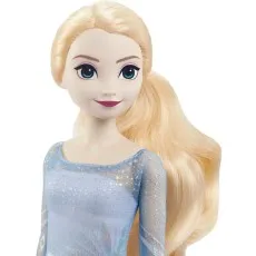 A close-up of the Elsa doll's face, showing her blue eyes, light makeup, and long blonde hair styled in a ponytail