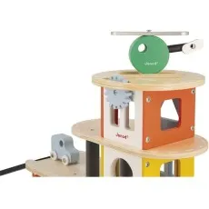 A detailed shot of a Janod toy, showing a helicopter and gears on a wooden garage.