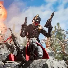 A diorama of a Cobra Iron Grenadier figure kneeling on rocks, dual-wielding guns