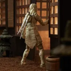 A G.I. Joe action figure of Storm Shadow, wearing a white ninja outfit, with katanas on his back, approaching a door in a diorama
