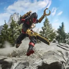 A Cobra Iron Grenadier B.A.T. action figure is shown mid-jump, holding a chainsaw and a claw attachment