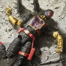 A detailed shot of a G.I. Joe Classified Series Cobra Iron Grenadier B.A.T. action figure lying on the ground