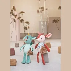 A plush deer and a plush dragon toy, both with musical harps, posed artistically.