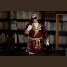 An action figure of the Invisible Man posed at a desk, with a hat and lab equipment.