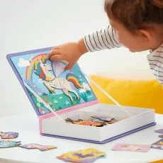 A child playing with the Janod Magnéti'book, placing a winged unicorn magnet on the scene.