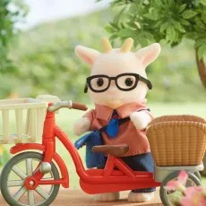 The father goat figure from Sylvanian Families on a red tricycle with a white basket.