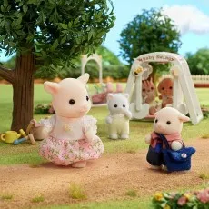 The Sylvanian Families goat daughter and son figures in a park with a baby swing and other figures in the background.