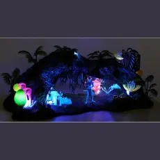 An Avatar toy scene glowing in the dark, showing a figure, plants, and an arch with blue lights.