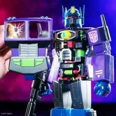 Close-up of Optimus Prime toy with open chest and a hand holding the cracked windshield chest plate