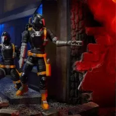 Two G.I. Joe B.A.T. figures stand in a destroyed building diorama