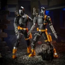 Two G.I. Joe B.A.T. figures stand next to a robotic accessory in a battle diorama
