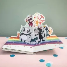 An open pop-up children's book with cartoon animals dancing on a rainbow.