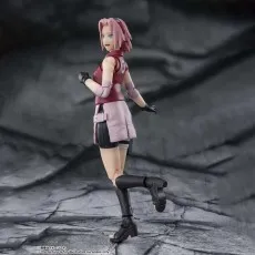 A side view of a Sakura Haruno figure in a dynamic pose, looking over her shoulder with one leg raised.