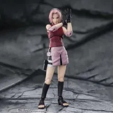 An action figure of Sakura Haruno in a fighting stance with one hand raised to block.