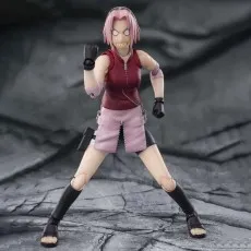 An action figure of Sakura with an angry, exaggerated face, posed in a wide-legged fighting stance.