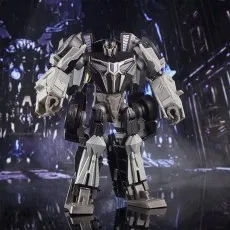 The Transformers Studio Series Barricade figure, a gray and black robot, stands in a futuristic city scene.