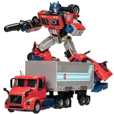 Transformers Optimus Prime robot figure standing on top of his alternate mode a red Volvo VNR semi-truck.