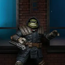 Close-up of the hooded Last Ronin action figure with a menacing grin, holding the metal grip of a weapon