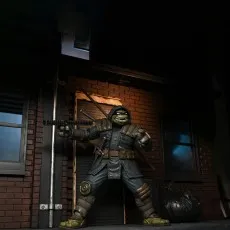 Full view of The Last Ronin action figure in an alley, aiming the chain-end of a kusarigama weapon