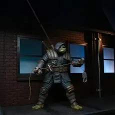 Full view of The Last Ronin action figure, holding a grappling hook on a rope in a dark alley setting