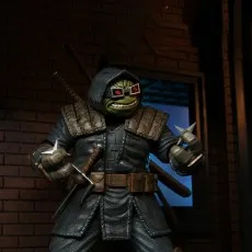 The Last Ronin action figure in a hooded cloak, wearing glasses and holding a shuriken, ready for battle