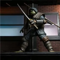 The Last Ronin action figure in an aggressive stance, wielding a katana on a rooftop diorama setting