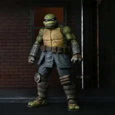 NECA's The Last Ronin action figure standing in an alley against a brick wall.