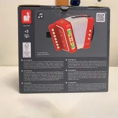 Top view of the Janod toy accordion box with a product image, size dimensions, and 3+ age warning