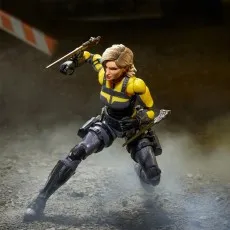 Dynamic shot of the Agent Helix toy in motion with two swords in a rubble-filled environment.