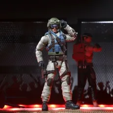 G.I. Joe Classified Airborne figure adjusting his helmet and saluting in a dimly lit, red-floored cage.