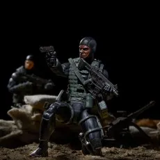 Action figure of a G.I. Joe Recon Diver kneeling, holding a pistol and a rifle, with another figure blurred behind.
