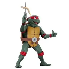 Close-up of TMNT Raphael toy with red mask, smiling, holding a sai with pizza on the tip, set against a brick wall.