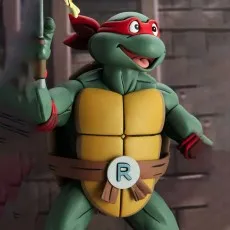 Teenage Mutant Ninja Turtles Raphael figure with a red mask, holding a slice of pizza on his sai.