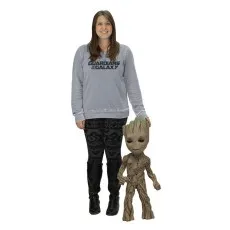 A woman wearing a Guardians of the Galaxy sweatshirt standing next to a life-size Baby Groot figure.