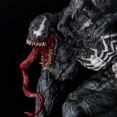 Extreme close-up of the Venom statue's face, showcasing sharp teeth, long red tongue, and white eyes..j
