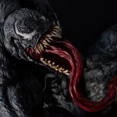Extreme close-up of the Venom statue's face, showing sharp fangs, long red tongue, and white eyes.