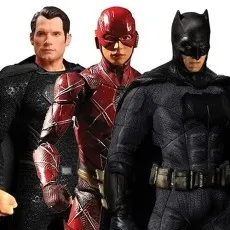 Close-up of three superhero action figures Superman in black, The Flash in red, and Batman in dark gray armor.