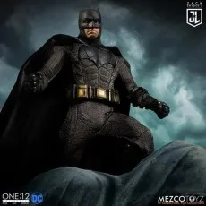 Mezco One12 Batman figure from Justice League, in a tactical suit, posed dramatically against a dark, cloudy sky.