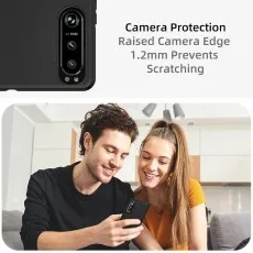 Close-up of phone case camera edge protection ($1.2text{mm}$) above a smiling couple viewing a smartphone.