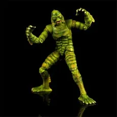 Creature from the Black Lagoon action figure posed menacingly with raised claws on a black reflective surface.